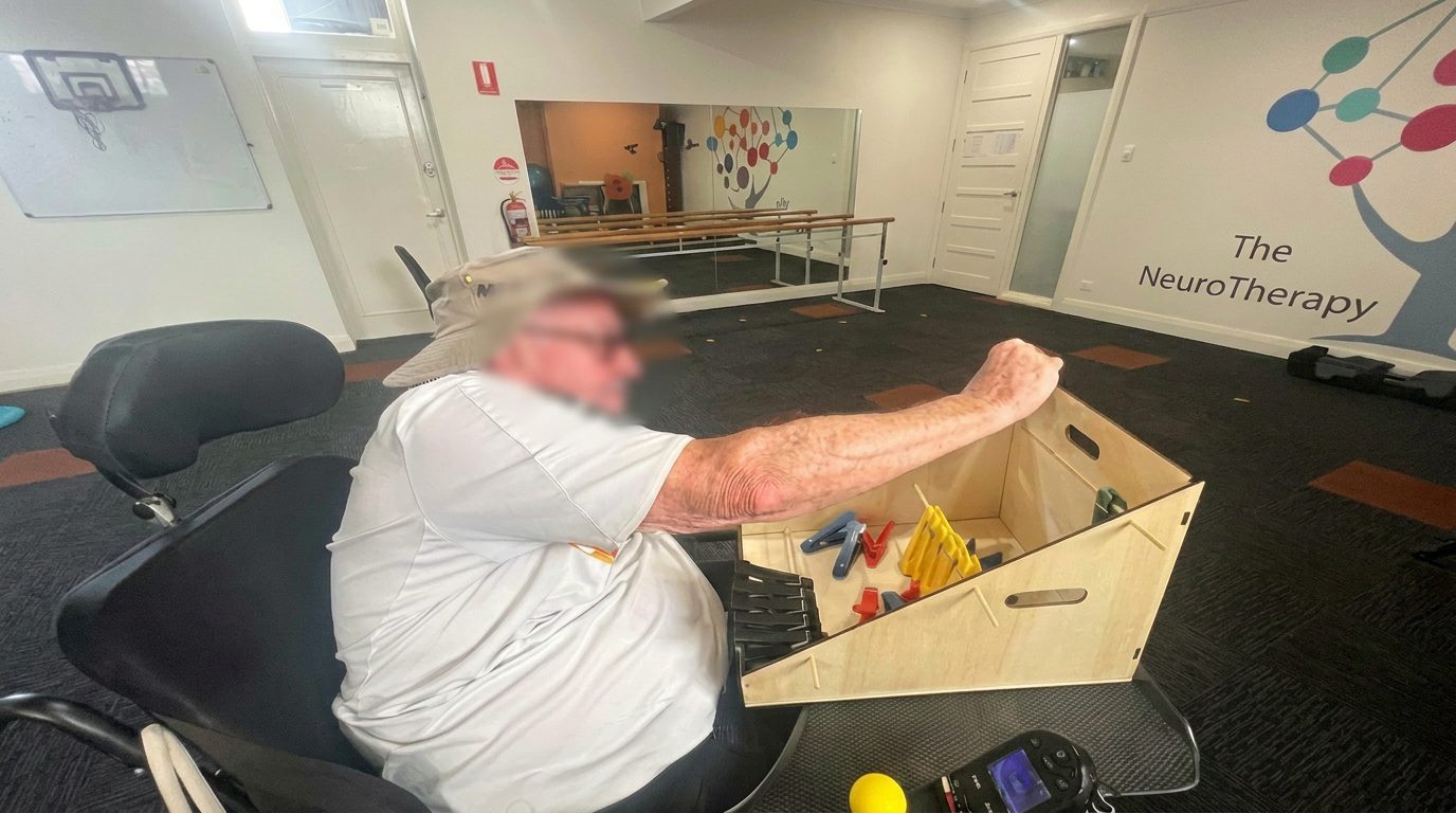 Seated participant working on functional reach and coordination in the NeuroTherapy Centre